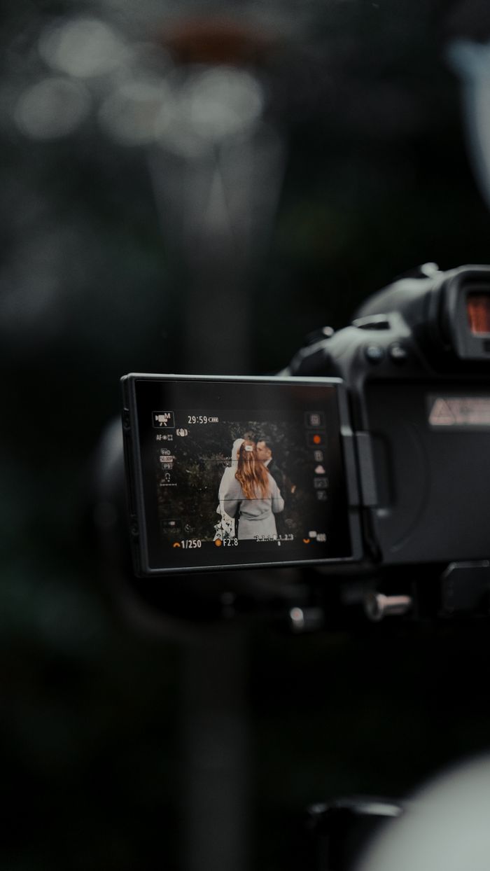 Close-up of camera screen showing a couple during wedding photography outdoors.